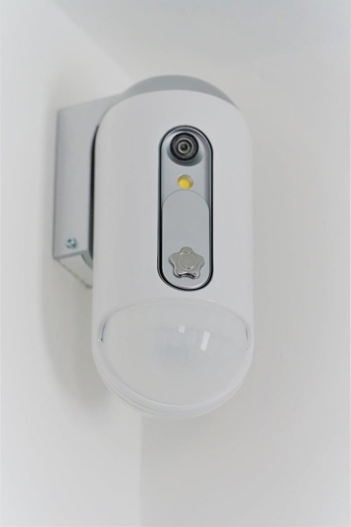 Close-up view of a contemporary indoor surveillance camera mounted on a wall for security monitoring.
